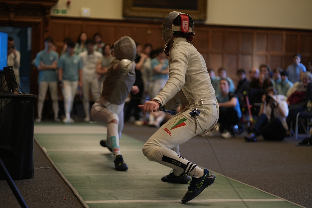 Tom fencing indoors during a bout